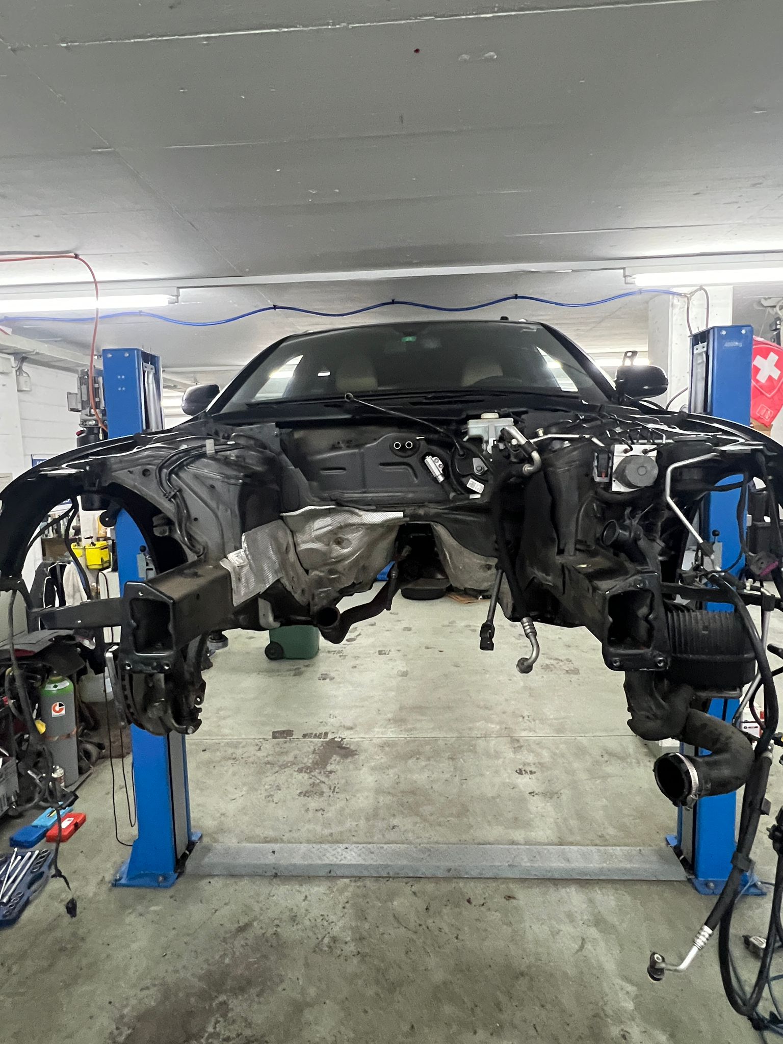 Fahrzeug mit abgebauter Front auf der Hebebühne in der Werkstatt